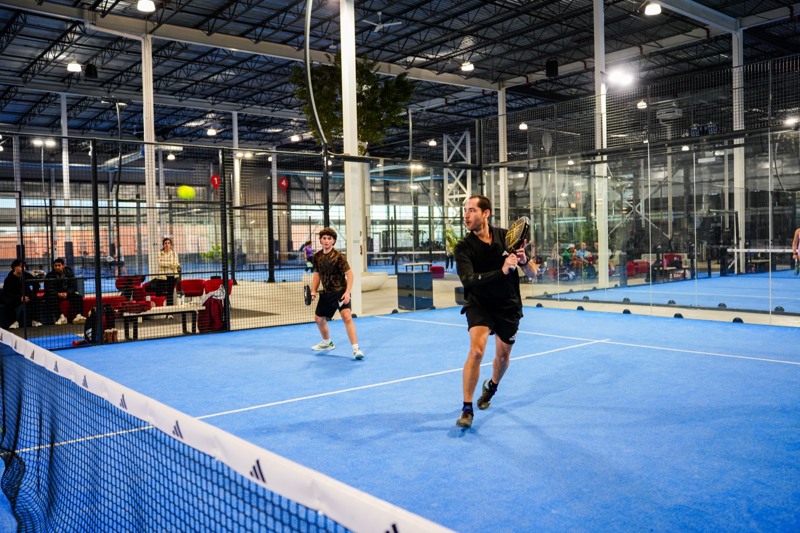 Wide view of CourtX Oakville padel courts in play